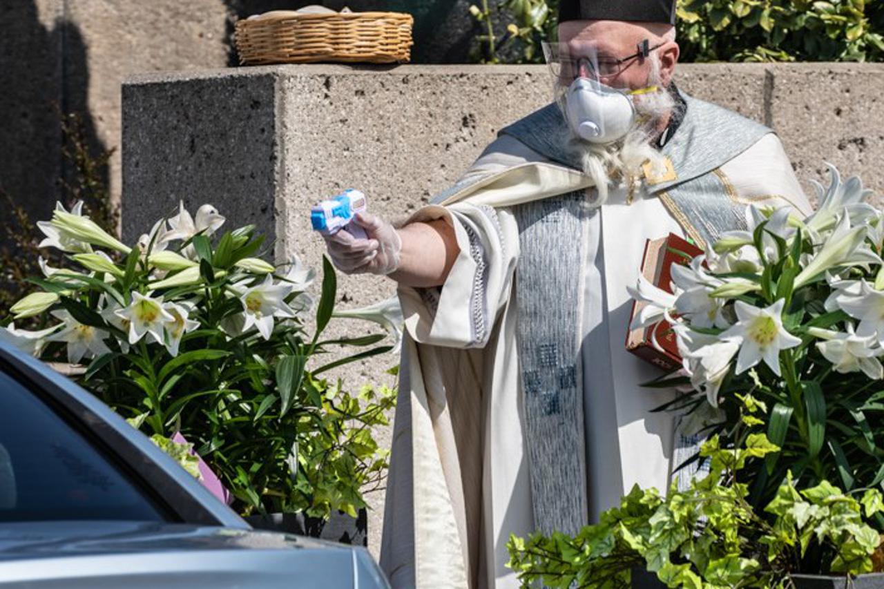 Svećenik blagoslovio ljude sa svetom vodom iz plastičnog pištolja