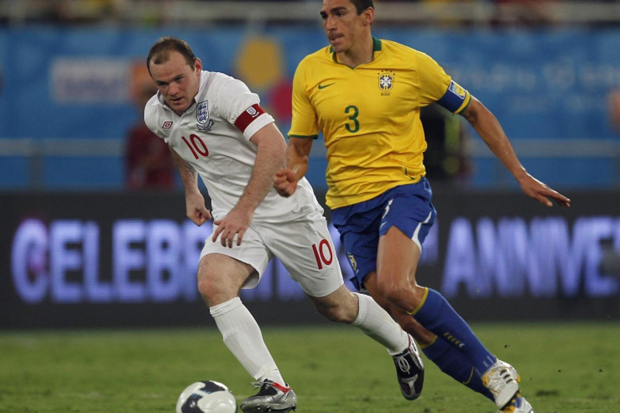 'England\'s Wayne Rooney (L) chases Brazil\'s Lucio during their international friendly soccer match at the Khalifa Stadium in Doha November 14, 2009.    REUTERS/Eddie Keogh (QATAR SPORT SOCCER)'