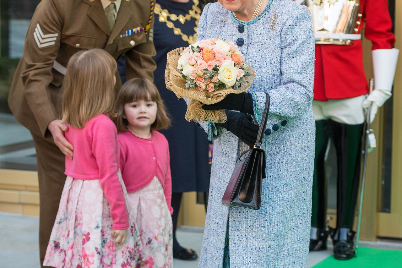 Queen reopens the National Army Museum Queen Elizabeth II smiles after she was presented with a posy of flowers by a child as she leaves after officially reopening the National Army Museum at the Royal Hospital Road, Chelsea. Dominic Lipinski  Photo: Pres