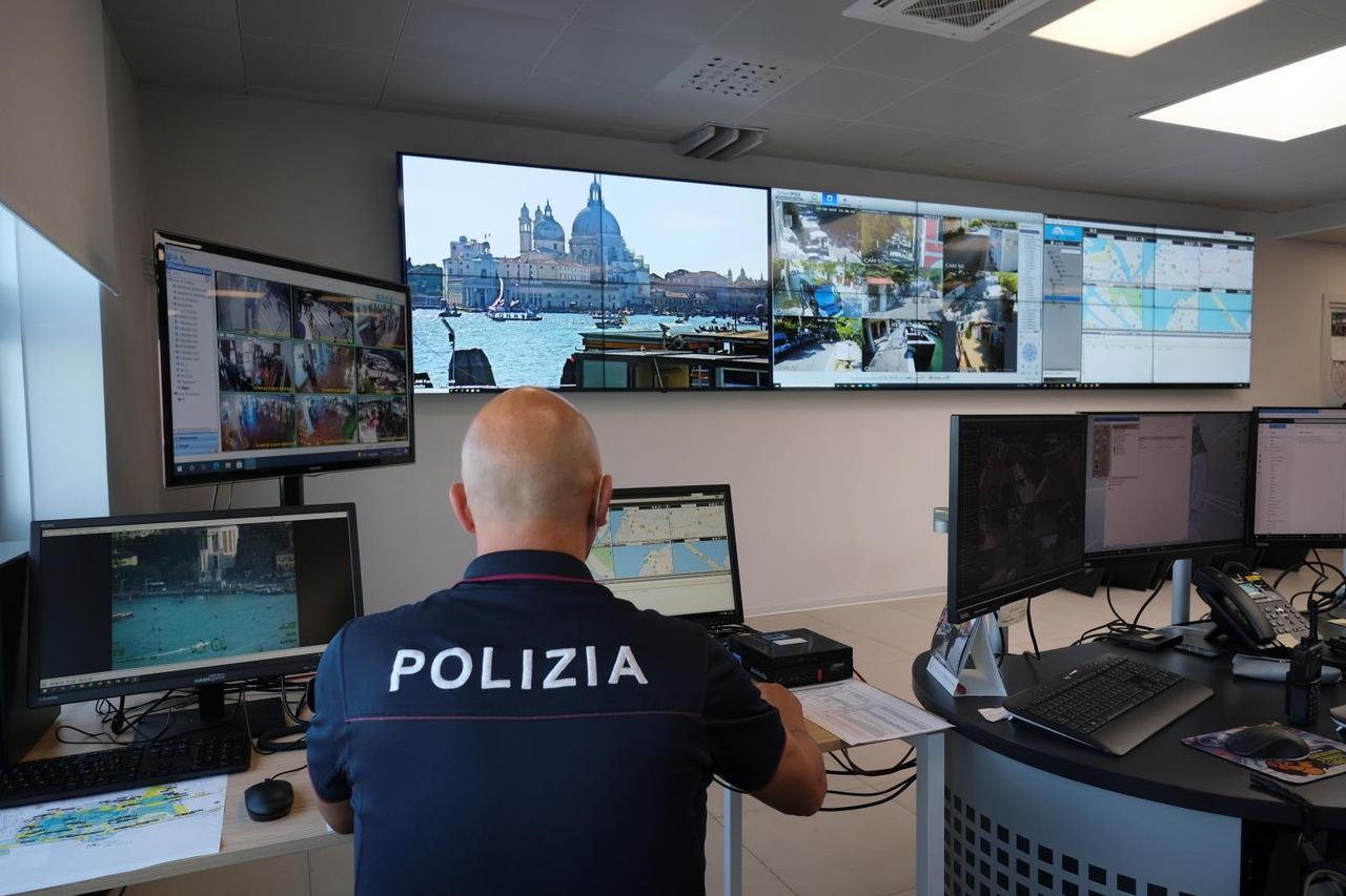 A police officer looks at monitors overseeing the lagoon city, in Venice