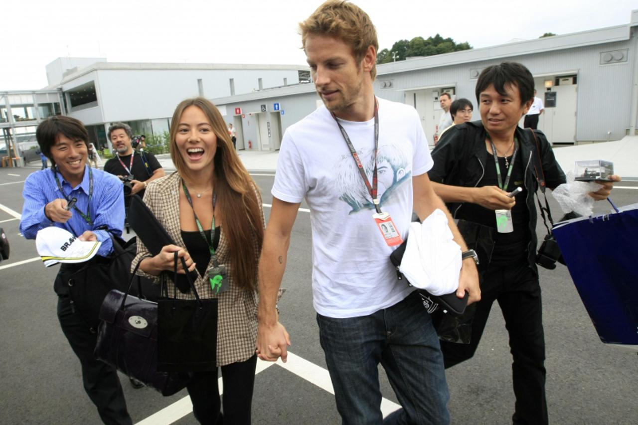 'Brawn GP Formula One driver Jenson Button of Britain ( 2nd R) and his girlfriend Jessica Michibata arrive at a circuit for the Japanese F1 Grand Prix in Suzuka, central Japan, October 1, 2009.  REUTE