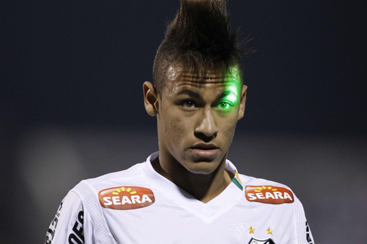 'A laser from the public hits Neymar of Brazil\'s Santos in the eye as they played Paraguay\'s Cerro Porteno in a Copa Libertadores semi-final soccer match in Asuncion June 1, 2011.    REUTERS/Jorge A