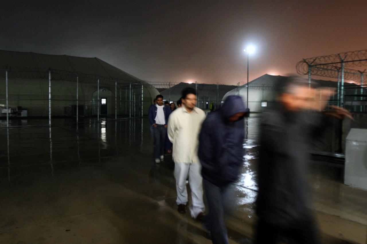 'Salvadorean detainees leave their barracks before embarking onto a bus to be taken to the airport, at Willacy Detention facility in Raymondville, Texas on December 18, 2008 early morning. The Willacy