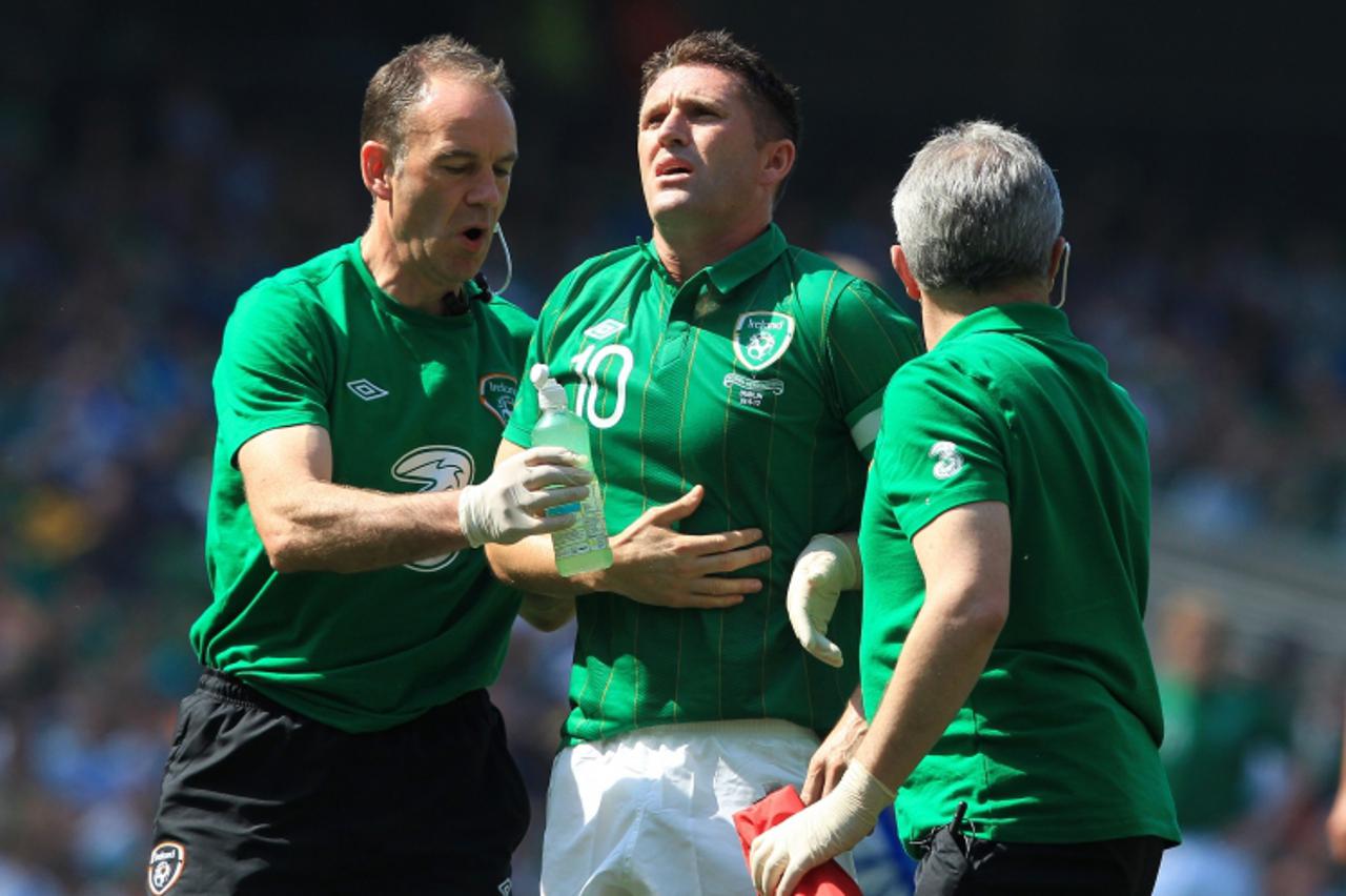 'Republic of Ireland\'s Robbie Keane (C) holds his ribs after being kicked during an international friendly football match against Bosnia-Herzegovina at the Aviva stadium in Dublin on May 26, 2012. AF