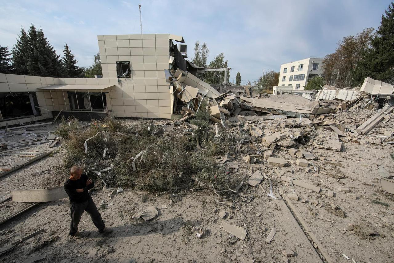 A man observes a building of Employment Center destroyed by a night Russian military strike, in Derhachi