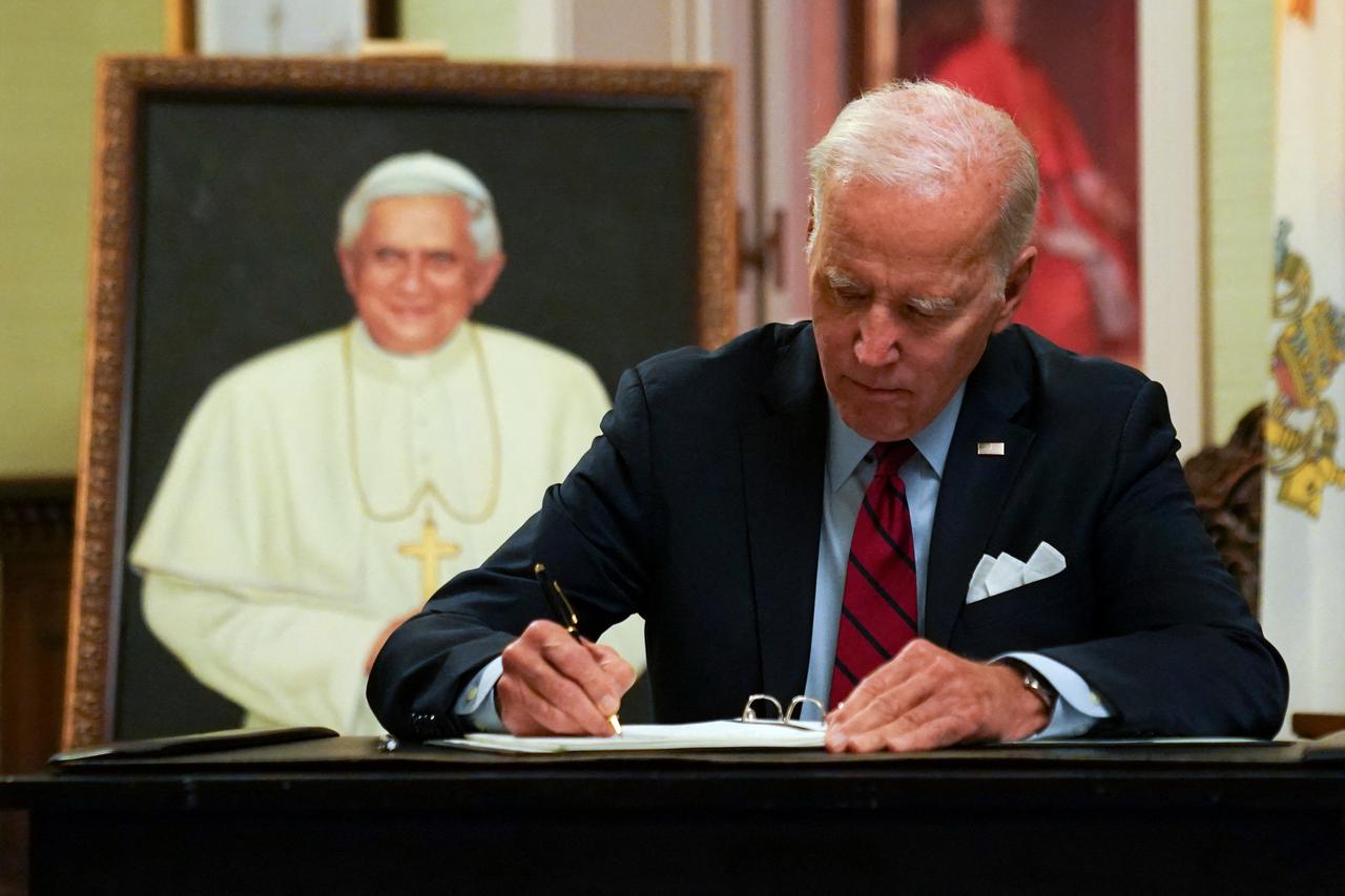 U.S. President Joe Biden signs a book of condolences for former Pope Benedict, in Washington