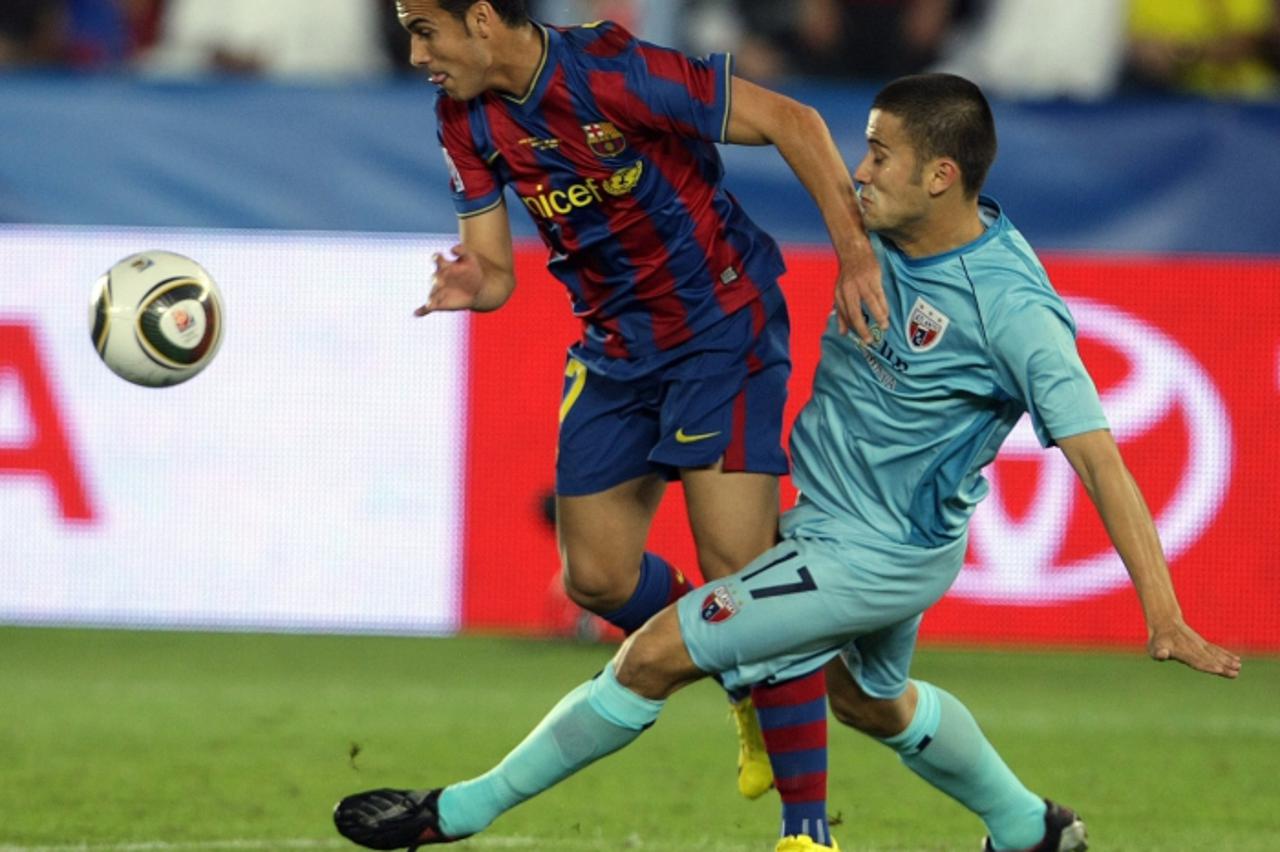 'Mexico\'s Atlante player Jose Guerrero (R) vies with Pedro of Spain\'s Barcelona during their FIFA Club World Cup semi-final football match in Abu Dhabi, December 16, 2009.  AFP PHOTO/KARIM SAHIB'