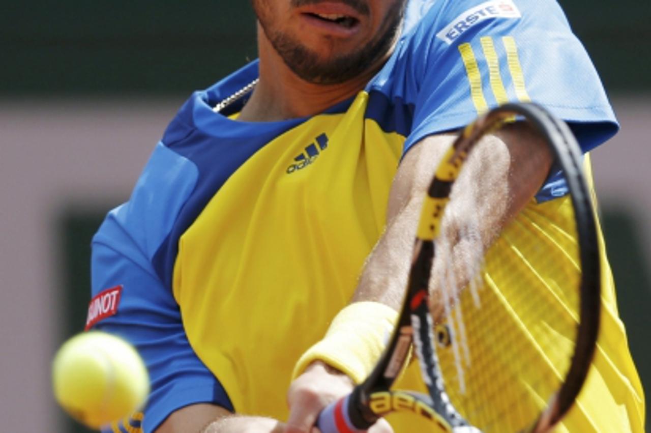 'Viktor Troicki of Serbia hits a return to Jo-Wilfried Tsonga of France during their men\'s singles match at the French Open tennis tournament at the Roland Garros stadium in Paris June 2, 2013. REUTE
