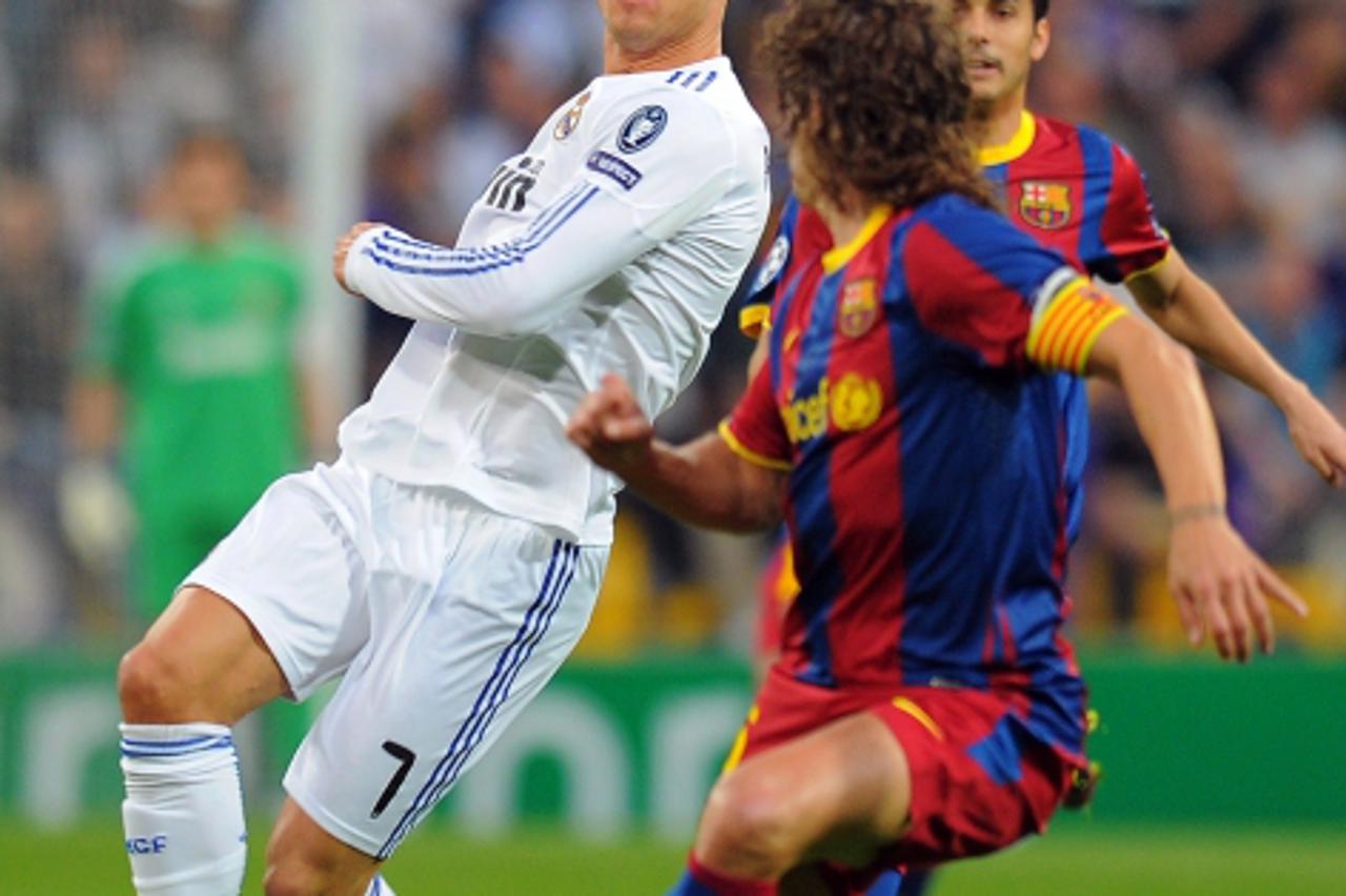 'Real Madrid\'s Portuguese forward Cristiano Ronaldo (L) vies with Barcelona\'s captain Carles Puyol (L) during the Champions League semi-final first leg football match between Real Madrid and Barcelo