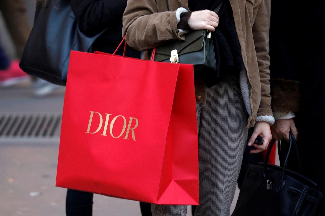 FILE PHOTO: A shopper carries a Dior shopping bag as she takes care of her last-minute Christmas holiday gift purchases in Paris