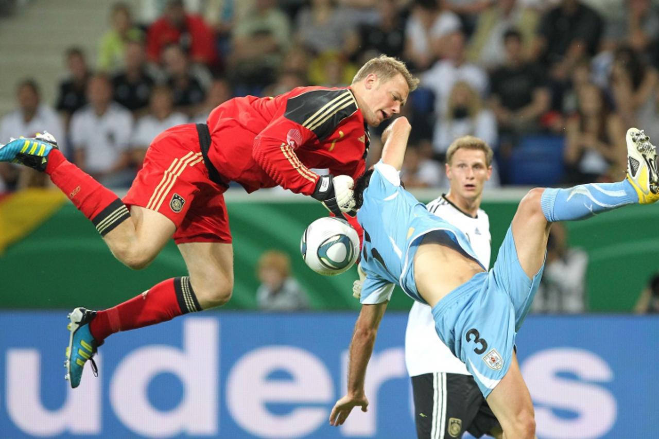 'Germany\'s goalkeeper Manuel Neuer (L) vies with Uruguay\'s defender Diego Godin during the friendly football match Germany vs. Uruguay in Sinsheim, southern Germany, on May 29, 2011. Germany won the