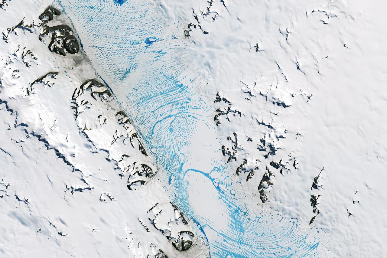 FILE PHOTO: Blue meltwater spans a vast area on the George VI ice shelf in Antarctica