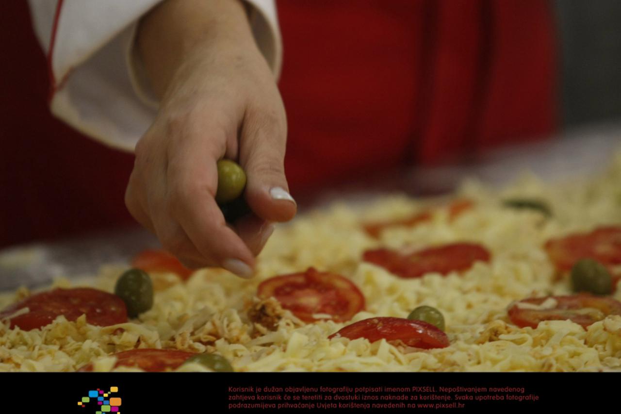 Workers prepare a 15-meter pizza for the 2nd edition of the Expo Pizzeria Fair, on the occasion of the Pizza Day, in Sao Paulo, Brazil, on July 10, 2012. After the event, the giant pizza will be donat