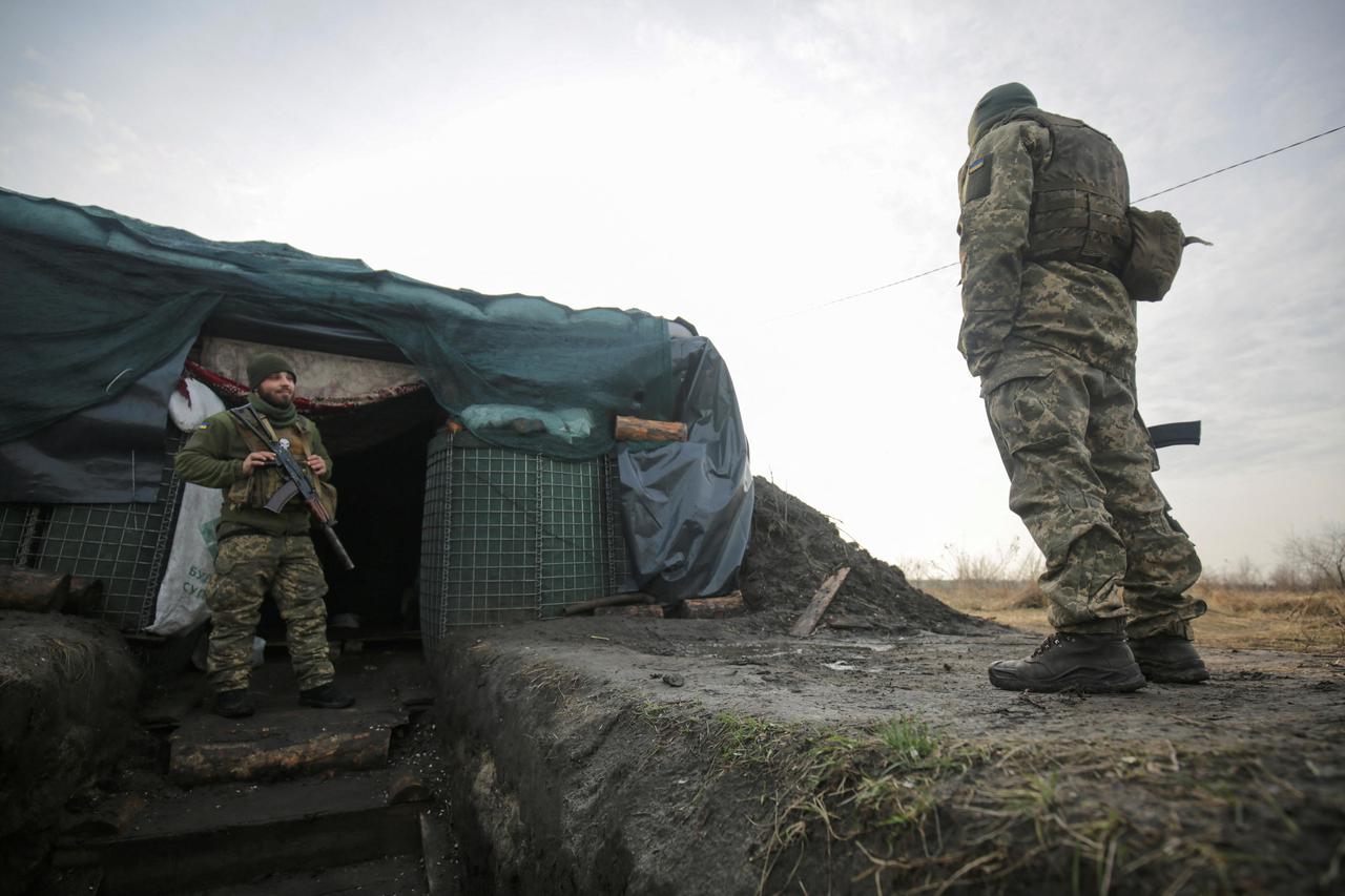 Service members of the Ukrainian armed forces stand guard at combat positions in the Luhansk region