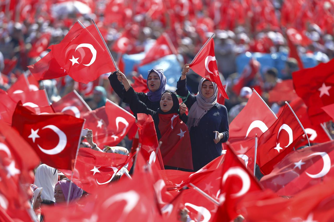 People wave Turkey's national flags during the Democracy and Martyrs Rally, organized by Turkish President Tayyip Erdogan and supported by ruling AK Party (AKP), oppositions Republican People's Party (CHP) and Nationalist Movement Party (MHP), to protest 