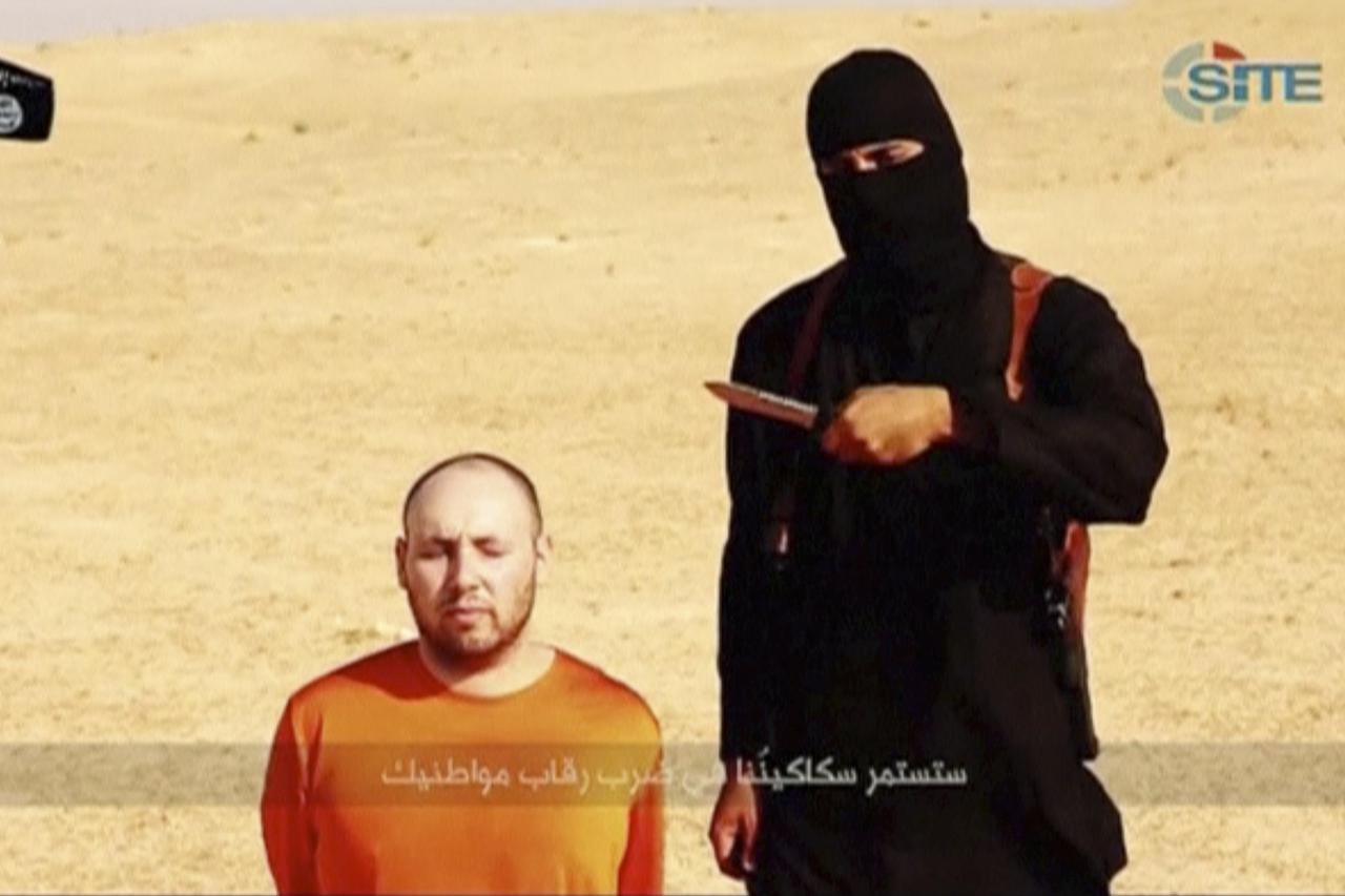 A masked, black-clad militant, who has been identified by the Washington Post newspaper as a Briton named Mohammed Emwazi, stands next to a man purported to be Steven Sotloff in this still image from a video obtained from SITE Intel Group website February