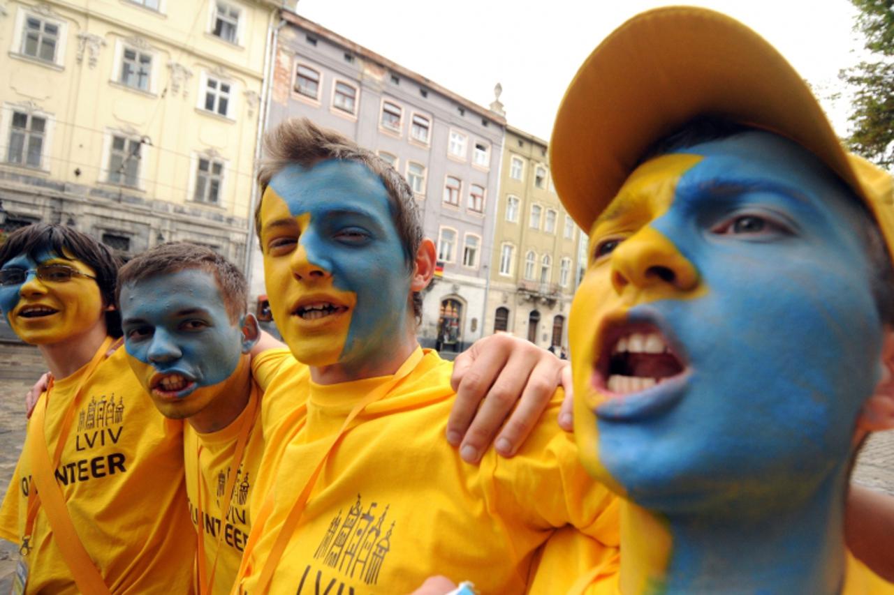 'Ukrainian fans cheer at a fan zone in the central Lviv ahead of the Euro 2012 football championships match Sweden vs Ukraine on June 11, 2012.        AFP PHOTO/ YURIY DYACHYSHYN'