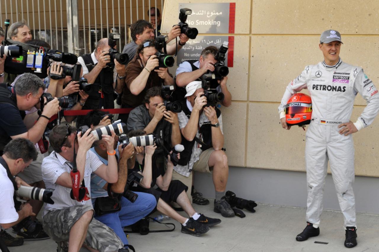 'Mercedes GP\'s German driver Michael Schumacher poses for photographers at the Bahrain international circuit on March 11, 2010 in Manama, three days ahead of the Bahrain Formula One Grand Prix.   AFP