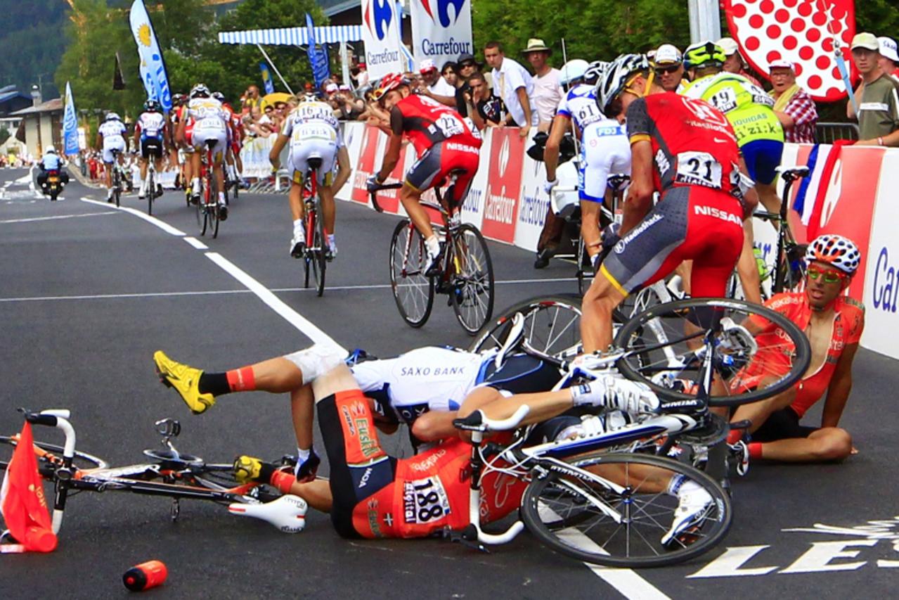 'Tour de France seven-times winner, US Lance Armstrong (2ndR), looks at riders after they crashed, Spain\'s Ivan Velasco (down), Spain\'s  Egoi Martinez (R) on July 11, 2010 in the 189 km and 8th stag