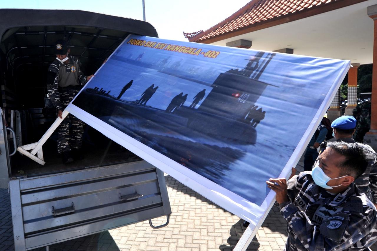 Indonesian Navy personnel carry a banner as they prepare the commander post for the searching operation of the submarine KRI Nanggala-402