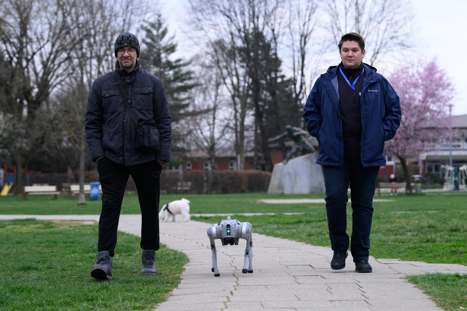 07.03.2024., Velika Gorica -  Milan Rajcevic, vlasnik i direktor tvrtke Notum Robotics sa suradnikom Ivanom Batinicem prosetao je Parkom dr. Franje Tudjmana u velikoj Gorici u drustvu robota psa. Za robota su podjednako bili zainteresirani prolaznici i njihovi ljubimci psi. Robot pas je komercijalni proizvod koji se radi po narudjbi, a ono sto je kod njega interesantno i unikatno su softverska rijesenja. Poanta je da ta platforma bude autonomna, bez ljudske intervencije i sa minimalnim odrzavanjem izvrsava zadatke prema svojem programu, da se snalazi u nepoznatim okolnostima, po nepoznatom terenu. Primjene su neogranicene, od sigurnosnih primjena, sluzbe spasavanja, nadzora te interakcije i edukacije. Puni se do 24 sata zbog tehnologije baterije i moze raditi do 3 sata, a trcati moze brzinom do 20 km/h. Trenutno nije vodootporan ali s vremenom moze postati i vodootporan i vatrootporan za siri spektar primjena. Ivan Batinic, Milan Rajcevic.
 Photo: Davor Puklavec/PIXSELL