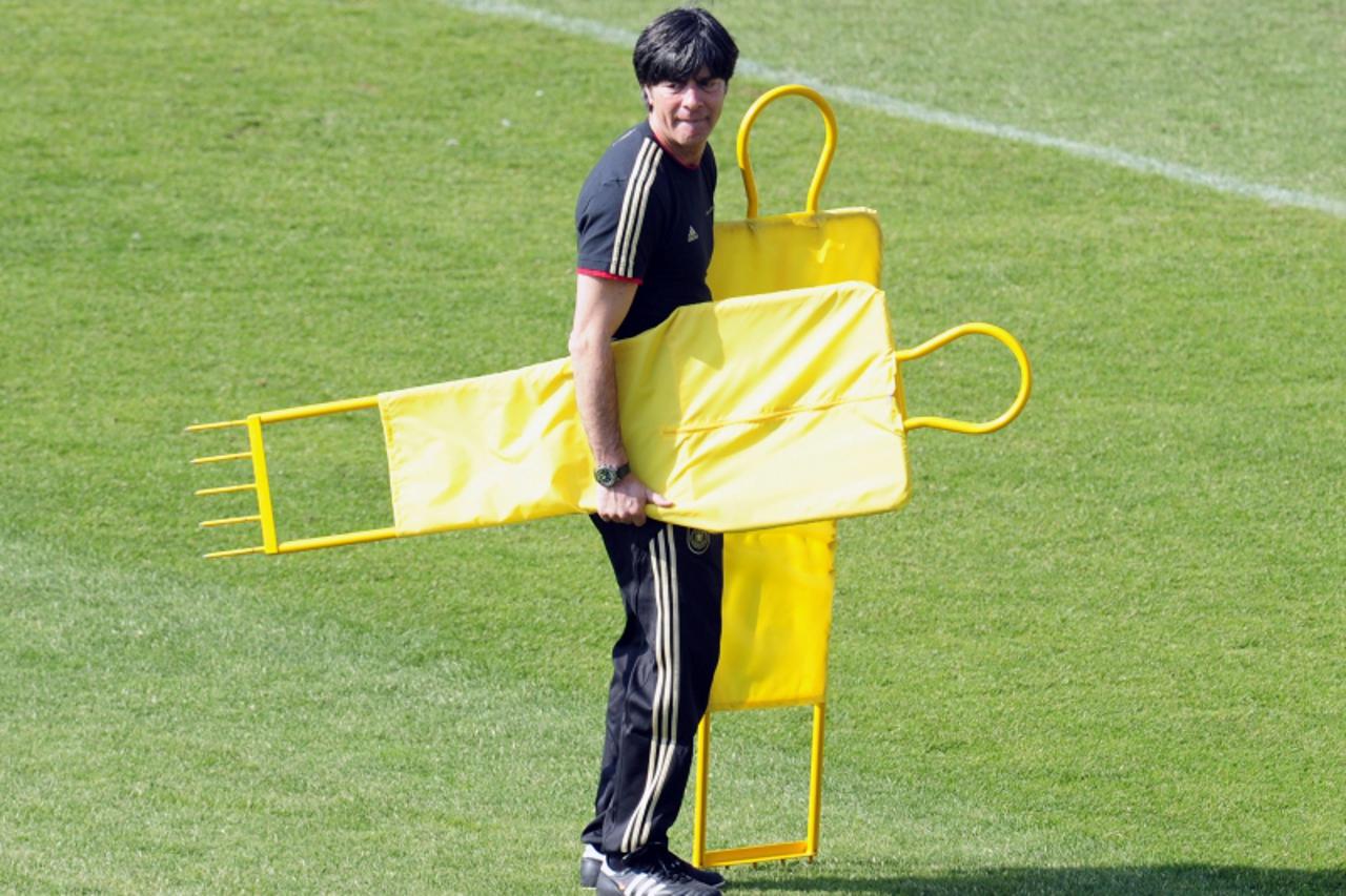 'Germany\'s coach Joachim Loew carries markers during a training session at the Super stadium in Atteridgeville near Pretoria  July 1, 2010 two days before their quarter final clash against Argentina 