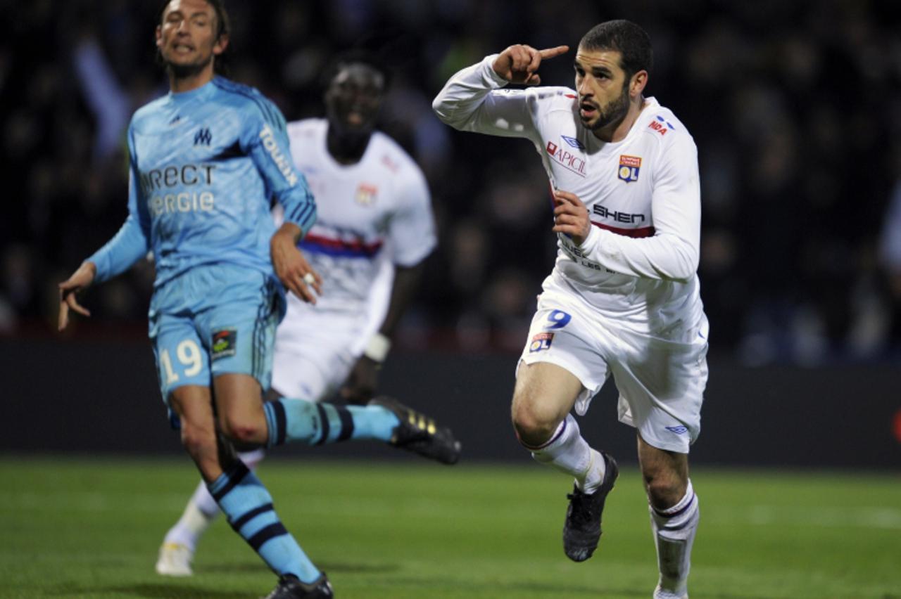 'Lyon\'s Argentinian forward Lisandro Lopez (R) celebrates after scoring a penalty during the French L1 football match Lyon vs. Marseille, on November 8, 2009 at the Gerland stadium in Lyon, eastern F
