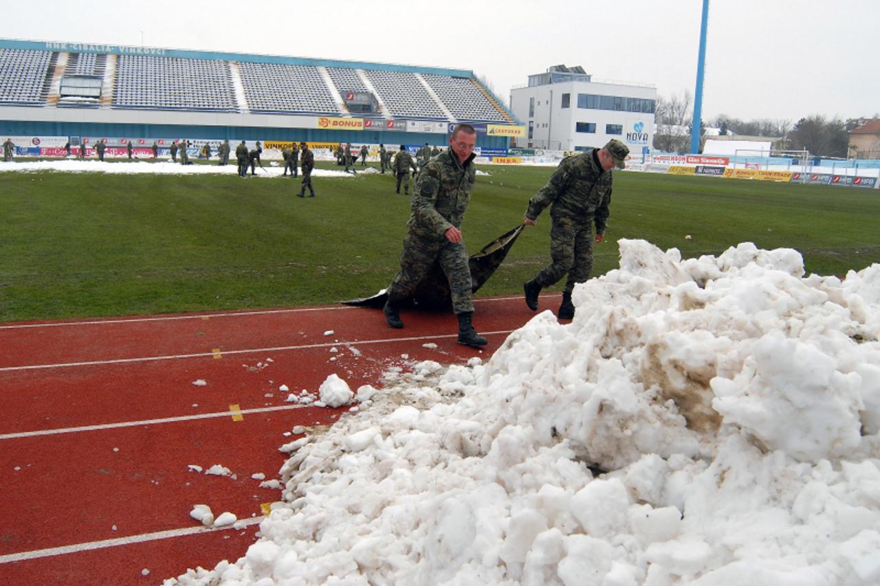 'Slavonija-Vinkovci-120310-pripadnici HV-a ciste snjeg sa travnjaka stadiona Cibalie kako bi ga pripremili za sutrasnju utakmicu  Photo: Goran Ferbezar/PIXSELL'