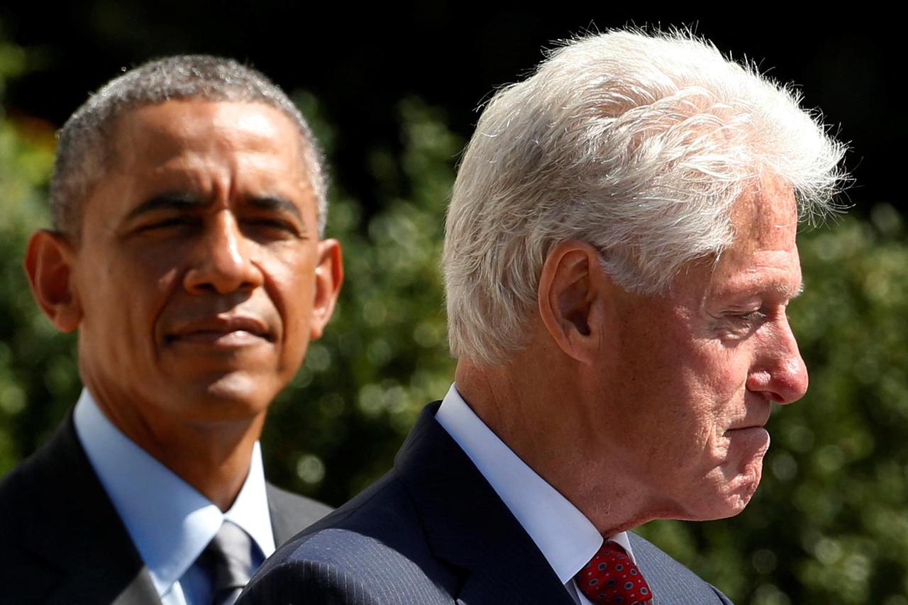FILE PHOTO: U.S. President Obama listens as former president Clinton makes remarks during an event in Washington
