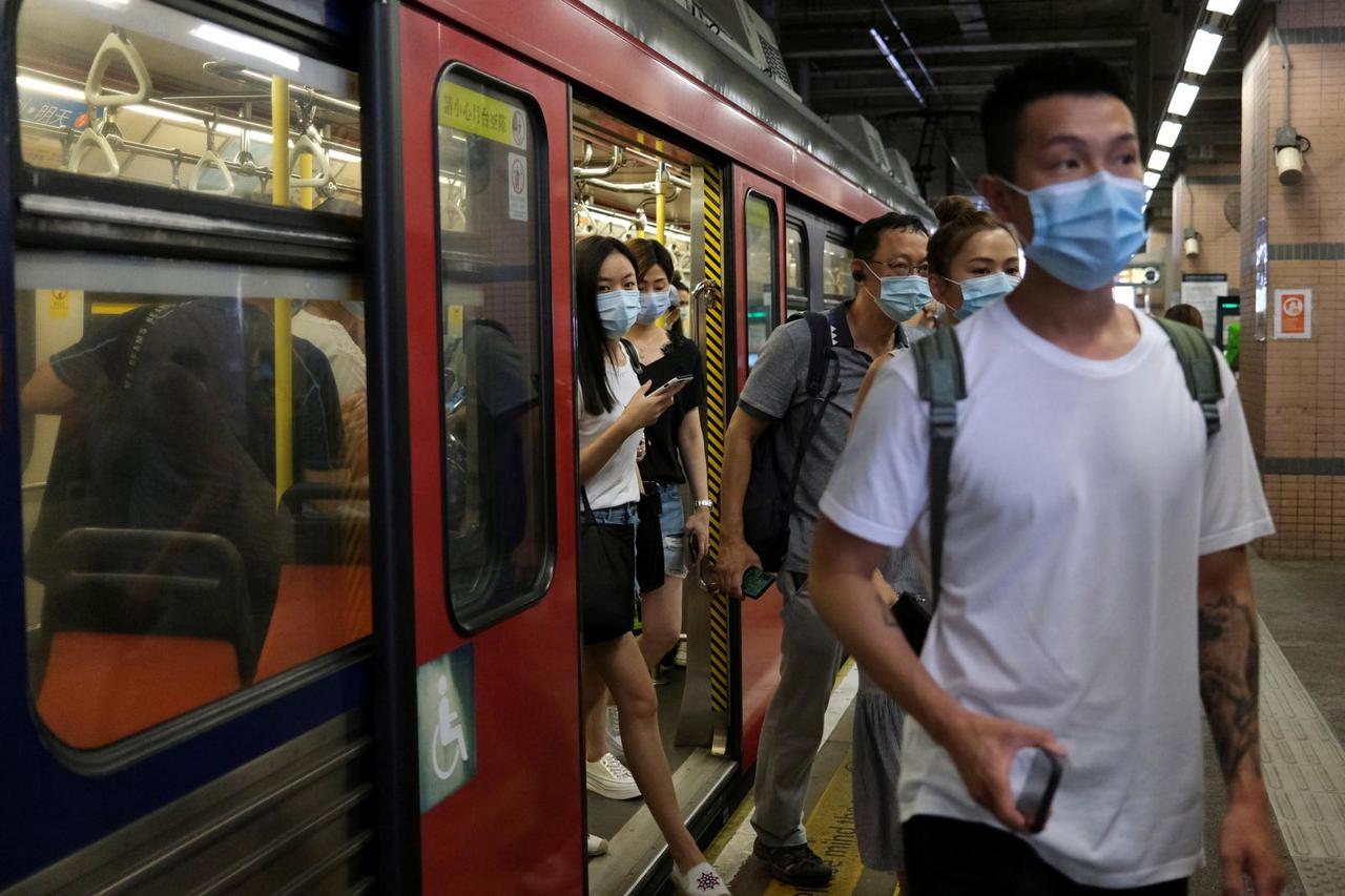FILE PHOTO: People wear protective face masks at a Light Rail station following the coronavirus disease (COVID-19) outbreak in Hong Kong