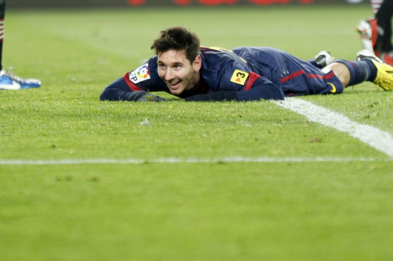 'Barcelona\'s Lionel Messi smiles on the grass after missing a chance to score a third goal during their Spanish first division soccer match against Athletic Bilbao at Nou Camp stadium in Barcelona De