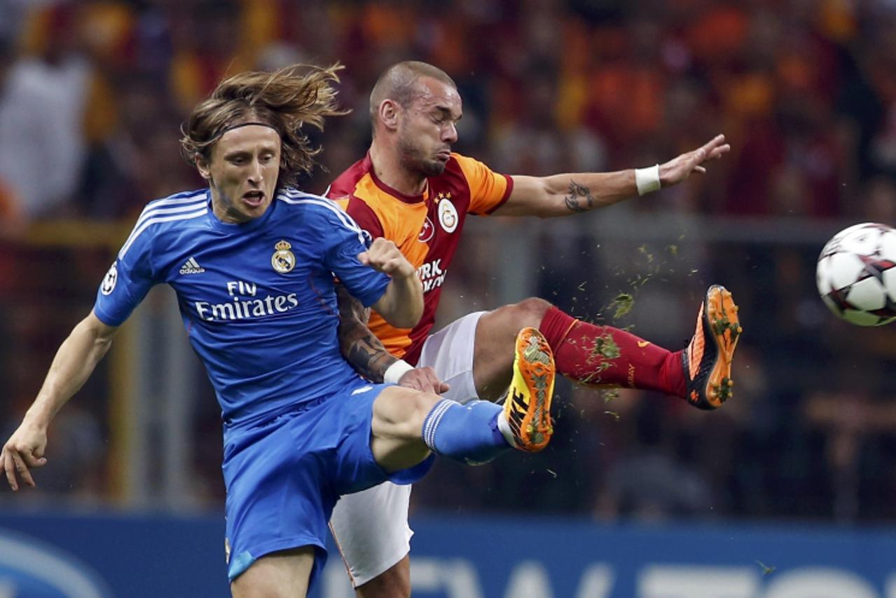 'Real Madrid\'s Luka Modric (L) challenges Galatasaray\'s Wesley Sneijder during their Champions League Group B soccer match at Turk Telekom Arena in Istanbul September 17, 2013.  REUTERS/Murad Sezer 