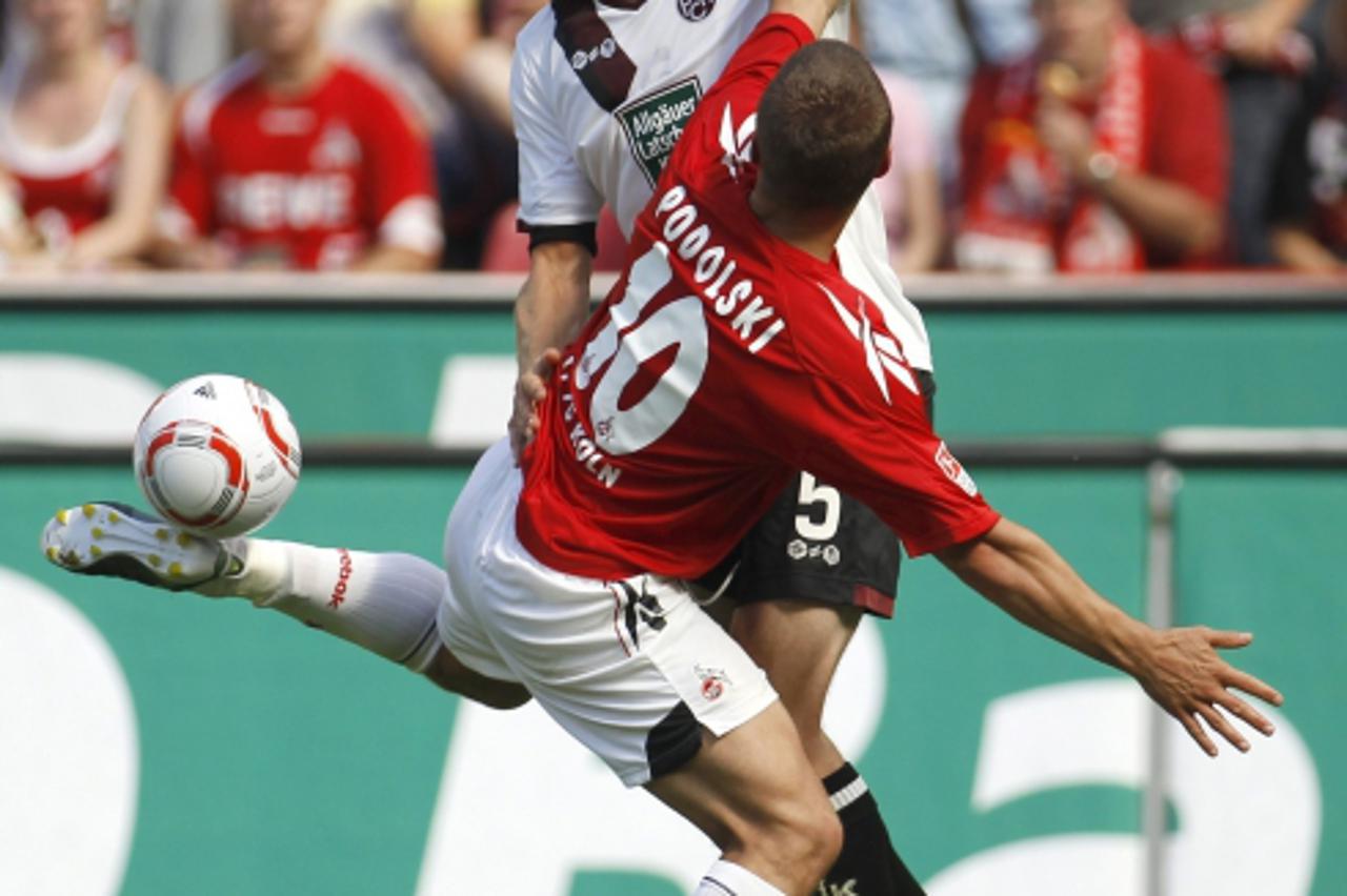 'Cologne\'s Lukas Podolski challenges Kaiserslautern\'s Martin Amedick (L) during the German Bundesliga soccer match in Cologne August 21, 2010. REUTERS/Ina  Fassbender (GERMANY - Tags: SPORT SOCCER I