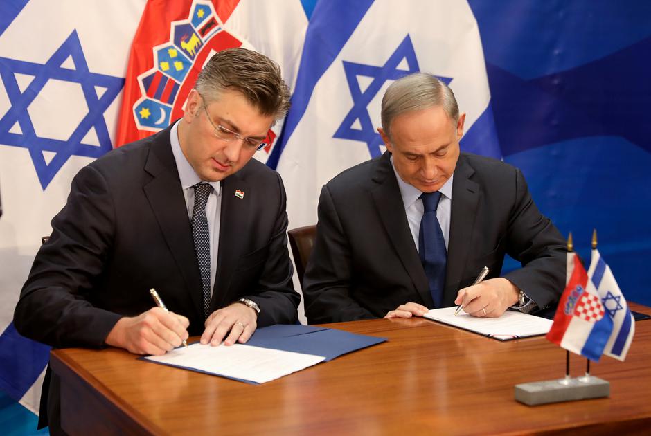 Israeli Prime Minister Benjamin Netanyahu (R) and his Croatian counterpart Andrej Plenkovic sign a bilateral agreement in Jerusalem January 24, 2017. REUTERS/Gali Tibbon/Pool