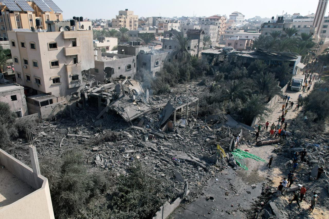 Palestinians gather at the site of an Israeli strike on a house, in Deir Al-Balah