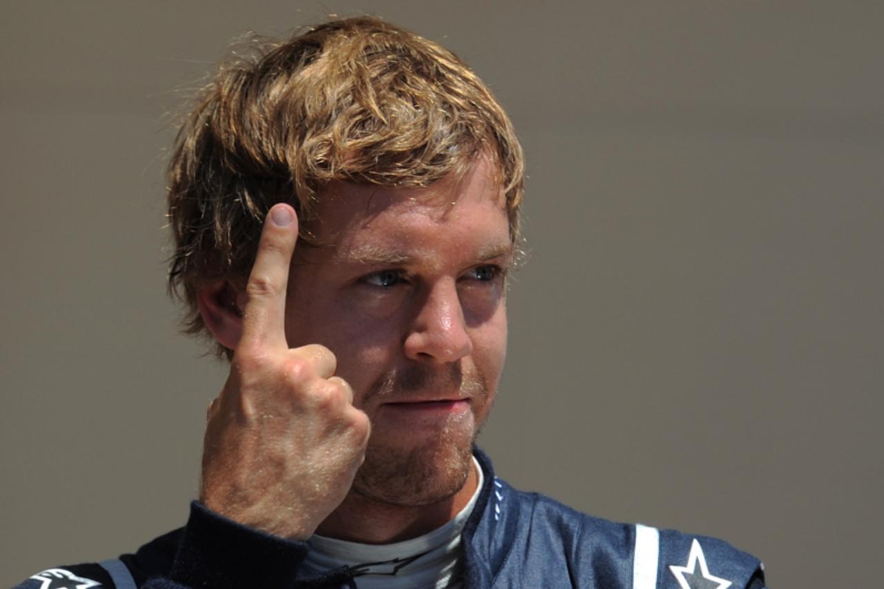\'Red Bull Racing\'s German driver Sebastian Vettel celebrates in the parc ferme  at the Valencia Street Circuit on June 25, 2011 in Valencia after the qualifying session of the European Formula One G