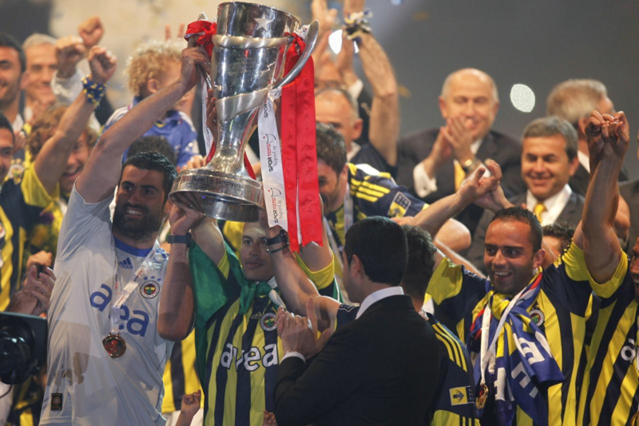 'Players and team members of Fenerbahce celebrate with the Turkish Super League trophy during a ceremony at Sukru Saracoglu stadium in Istanbul May 23, 2011. Fenerbahce won its 18th Turkish league tit