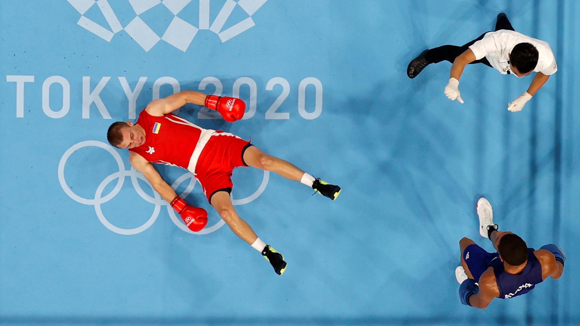 Boxing - Men's Middleweight - Final Tokyo 2020 Olympics - Boxing - Men's Middleweight - Final - Kokugikan Arena - Tokyo, Japan - August 7, 2021. Oleksandr Khyzhniak of Ukraine lies on the ground after being knocked down during his fight against Hebert Sousa of Brazil REUTERS/Ueslei Marcelino UESLEI MARCELINO