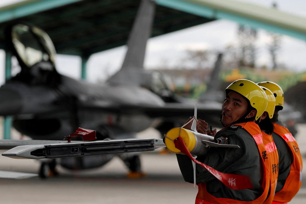 FILE PHOTO: Air force crews lift an AIM-9 Sidewinder air-to-air missiles to be loaded onto Northrop F-5 fighter during a military drill at Zhi-Hang Air Base in Taitung