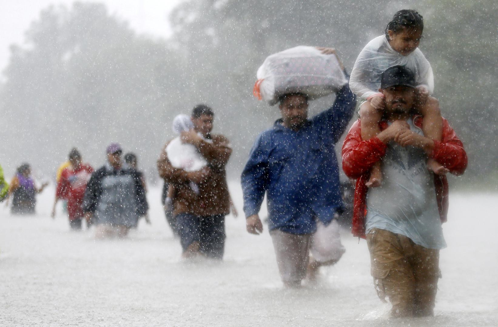 Stanovnici hodaju kroz poplavu nakon tropske oluje Harvey u Houstonu u Teksasu. 