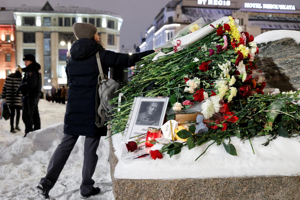 People gather at the monument to the victims of political repressions following the death of Alexei Navalny in Moscow
