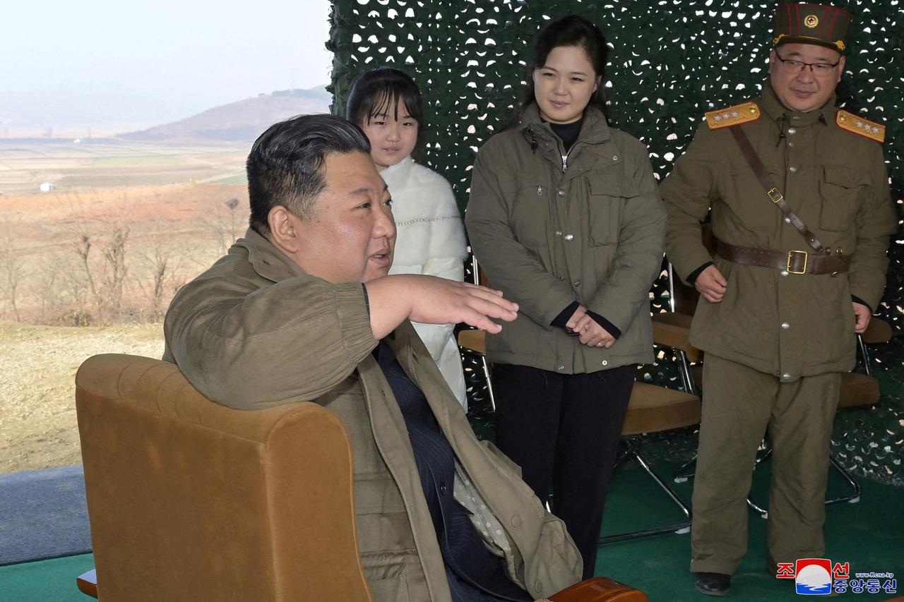 FILE PHOTO: North Korean leader Kim Jong Un, with his wife Ri Sol Ju and their daughter, speaks on the day of the launch of an ICBM in this undated photo released by KCNA