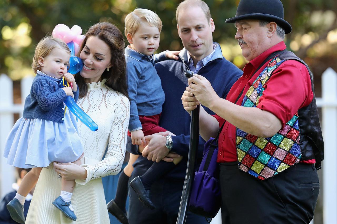 Royal Visit to Canada - Day Six The Duchess of Cambridge holding Princess Charlotte and Prince George being held by the Duke of Cambridge with an entertainer at a children's party at a children's party for Military families at Government House in Victoria