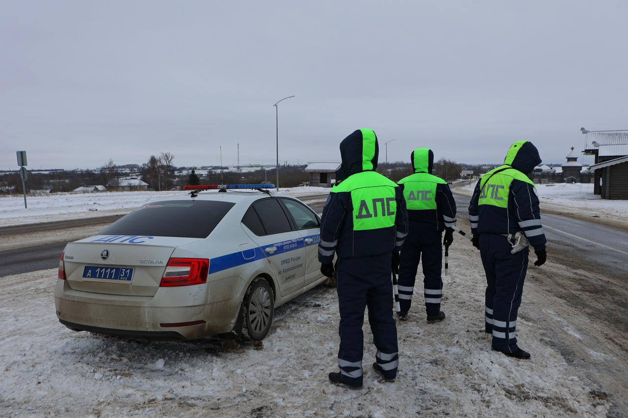 Traffic police officers block off a road near the crash site of the Russian Ilyushin Il-76 military transport plane in Belgorod Region