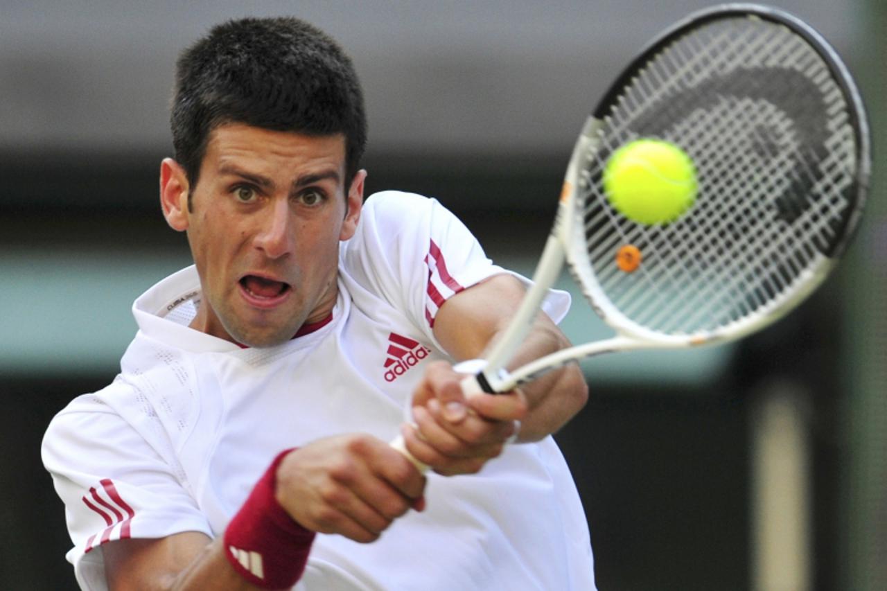 \'Novak Djokovic of Serbia returns the ball to Mardy Fish of the U.S. during their match at the Wimbledon tennis championships, in London June 26, 2009.   REUTERS/Toby Melville (BRITAIN SPORT TENNIS)\