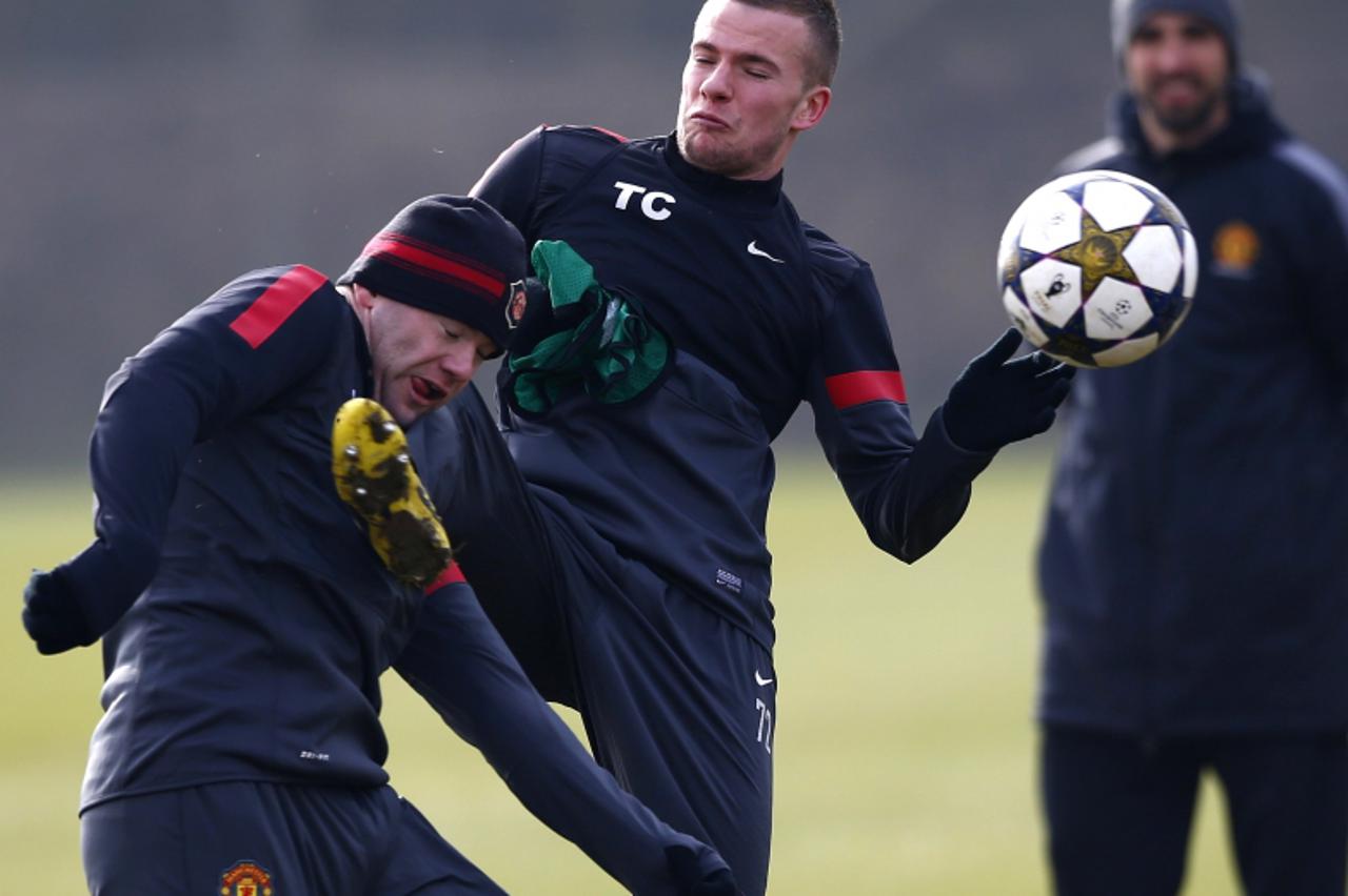 'Manchester United\'s Tom Cleverley (R) kicks Wayne Rooney in the face during a training session at the Carrington complex in Manchester, northern England, March 4, 2013. Manchester United will play R