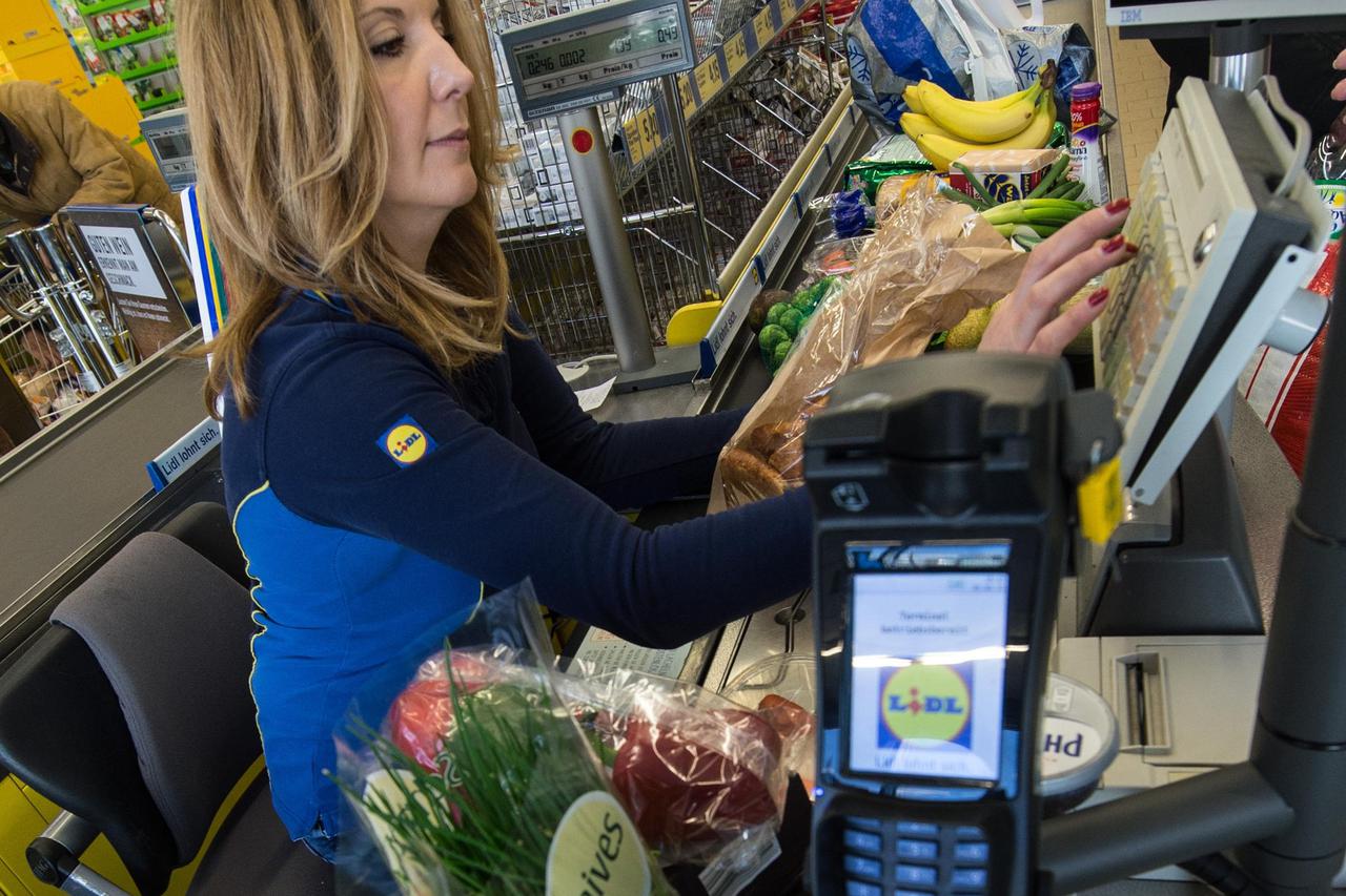 Staff member Violeta Greco sits at the cash register in a branch store of supermarket food discounter Lidl in Stuttgart, Germany, 3 March 2015.