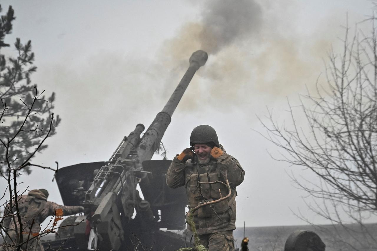 Ukrainian service members fire a shell from a howitzer at a front line in Zaporizhzhia Region