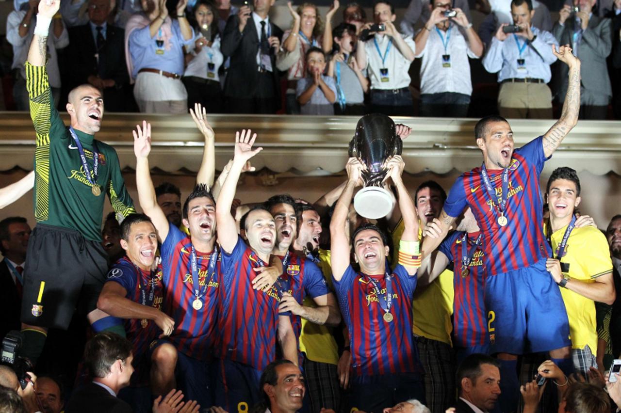 \'Barcelona\'s players celebrate with the trophy at the end of the UEFA Super Cup football match FC Barcelona vs FC Porto, on August 26, 2011 at the Louis II stadium in Monaco. Barcelona won 2-0. AFP 