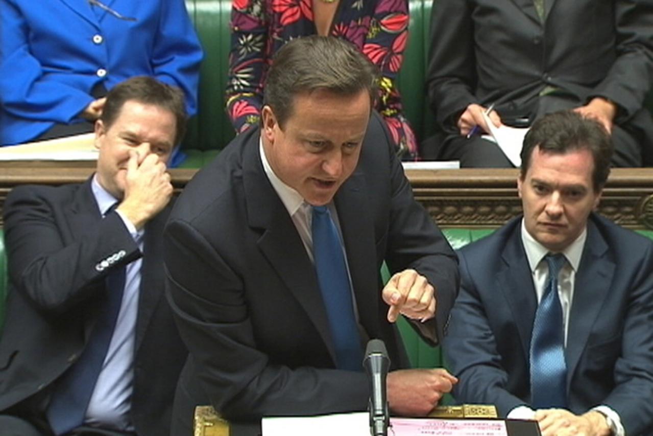 'Britain\'s Prime Minister David Cameron, flanked by Deputy Prime Minister Nick Clegg (L), and Chancellor of the Exchequer George Osborne, speaks to parliament during Prime Minister\'s Questions in th